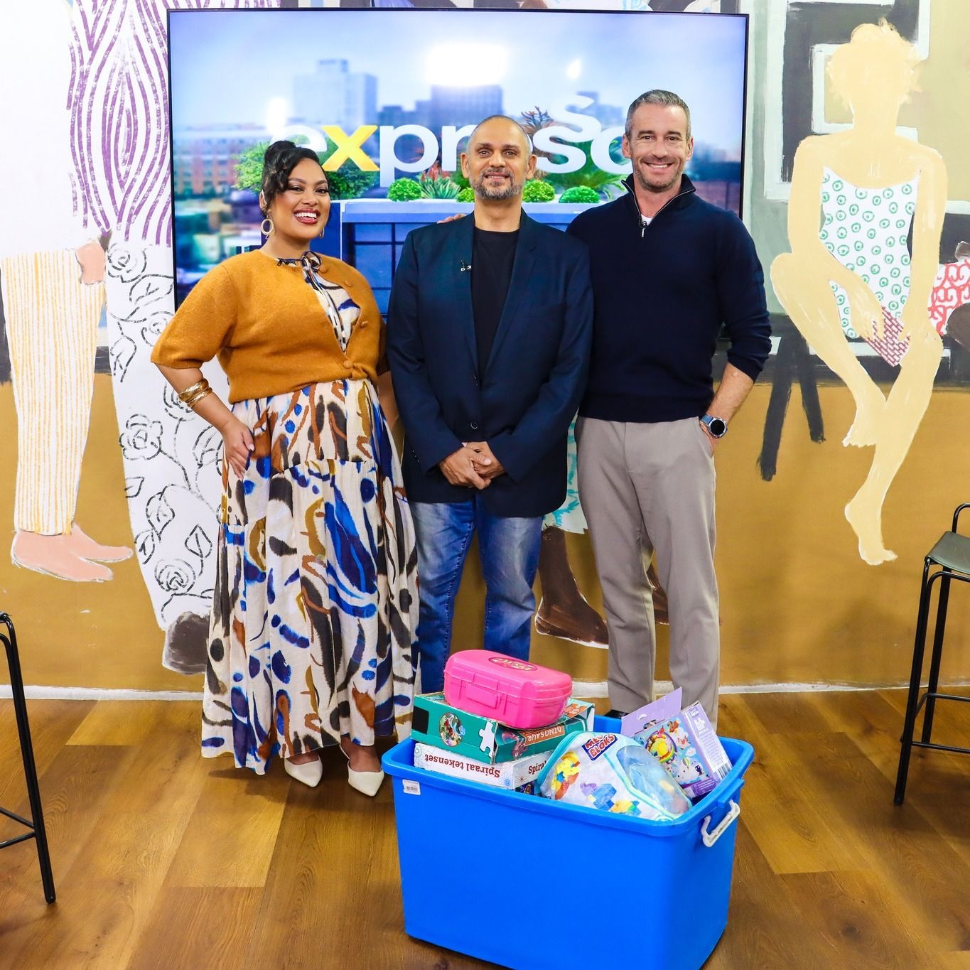 Expresso hosts and Zaid with a bin full of donated toys
